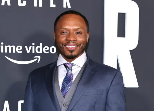 Malcolm Goodwin smiling at the camera, looking sharp.