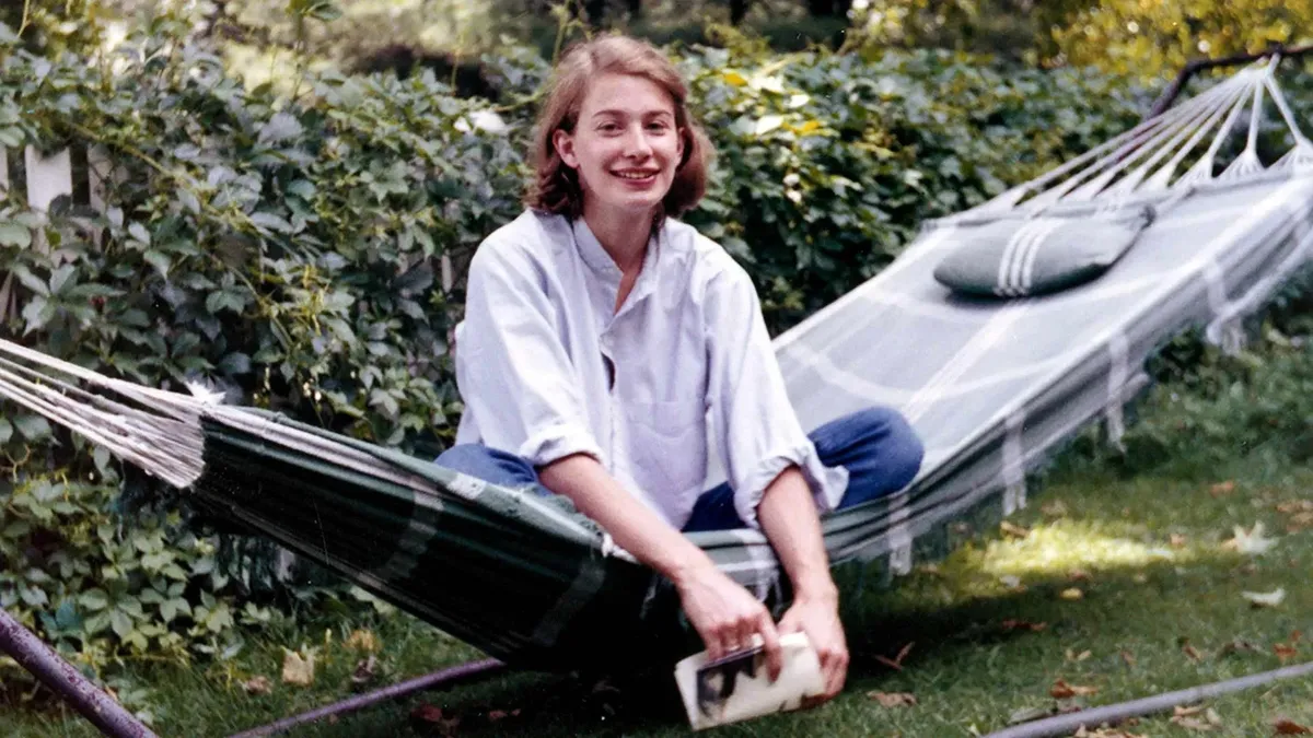 A serene photo of Mary Oliver, perhaps in a natural setting like a garden or forest.