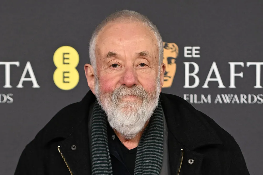 A photo of director Mike Leigh, an older man with glasses, smiling softly.