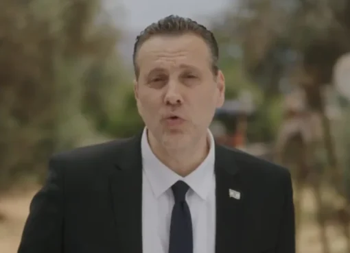 A serious-looking man, Miki Zohar, speaking in a campaign video.