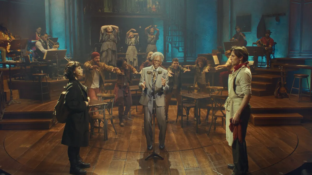 A stage scene from Hadestown with musicians and dancers, lit with warm, earthy tones, capturing a jamboree vibe.