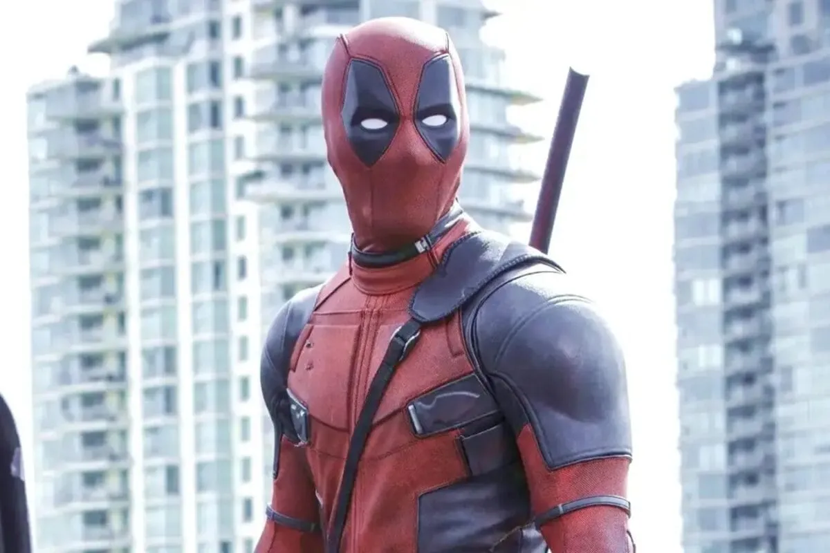 Close-up of Ryan Reynolds as Deadpool, wearing his iconic red and black suit, looking mischievous.