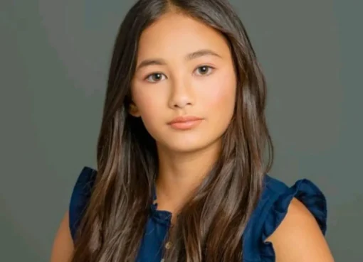 A young girl with dark hair looking up.