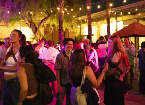 A vibrant image showing people gathered outside the Los Angeles LGBT Center's Renberg Theatre, with colorful film posters visible for Outfest.