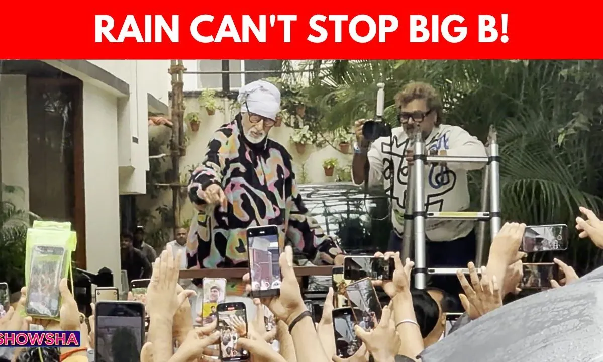 Amitabh Bachchan waves to fans outside his Jalsa residence during heavy Mumbai rains.