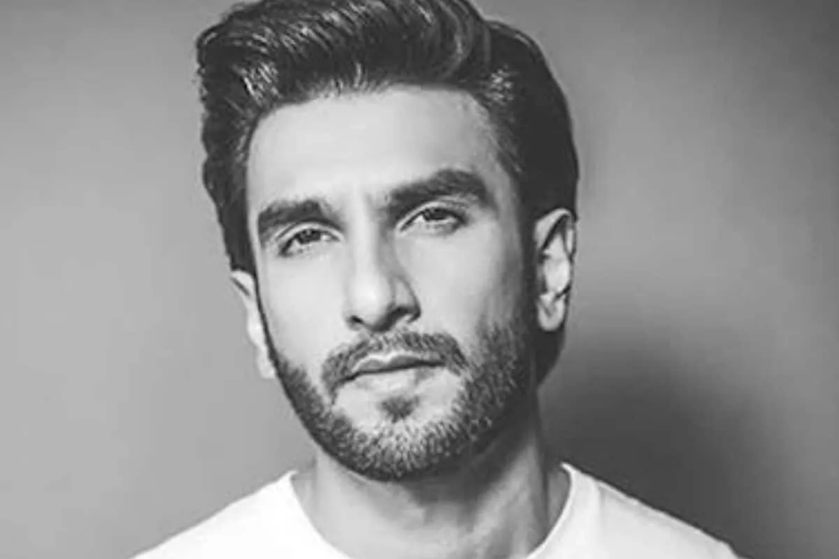 Ranveer Singh smiling with an intense backdrop