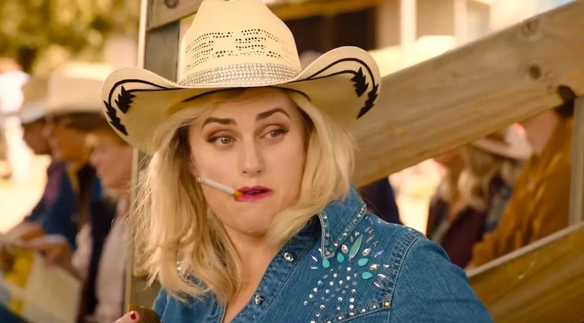 Rebel Wilson in a scene from her directorial debut 'The Deb' trailer, featuring vibrant colors.