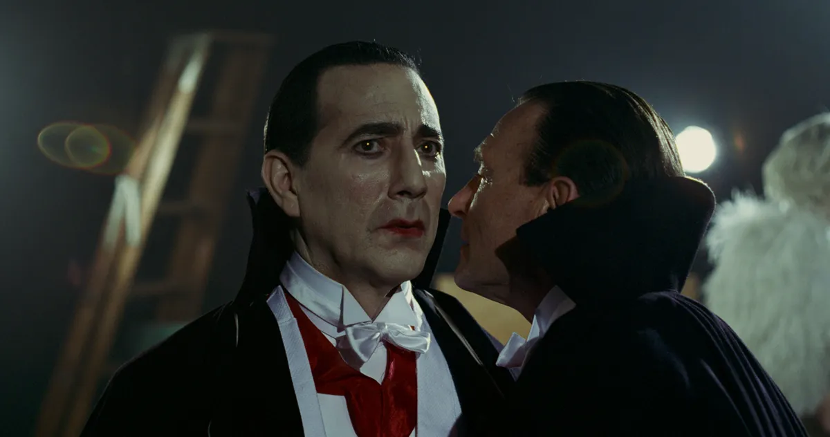An iconic black and white image of Dracula, cloaked and menacing, from an early Hollywood talkie film.