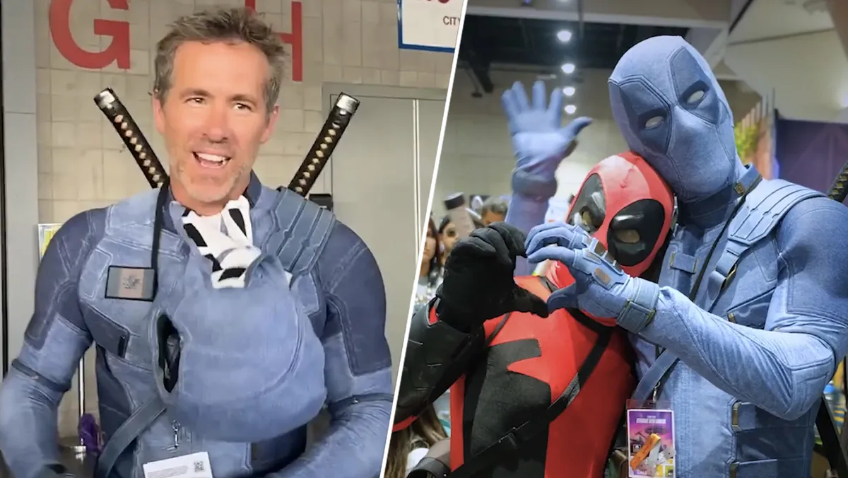 Ryan Reynolds in his red Deadpool costume walking through a crowd of fans
