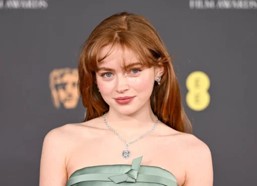 Sadie Sink as Felicia Hardy, the Black Cat, in a black leather suit looking mischievous and confident.