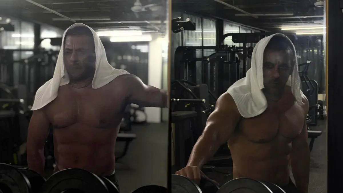Salman Khan shirtless in a gym, flexing his muscles with an intense expression.