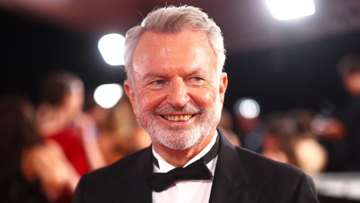 Sam Neill smiling warmly, looking thoughtful.