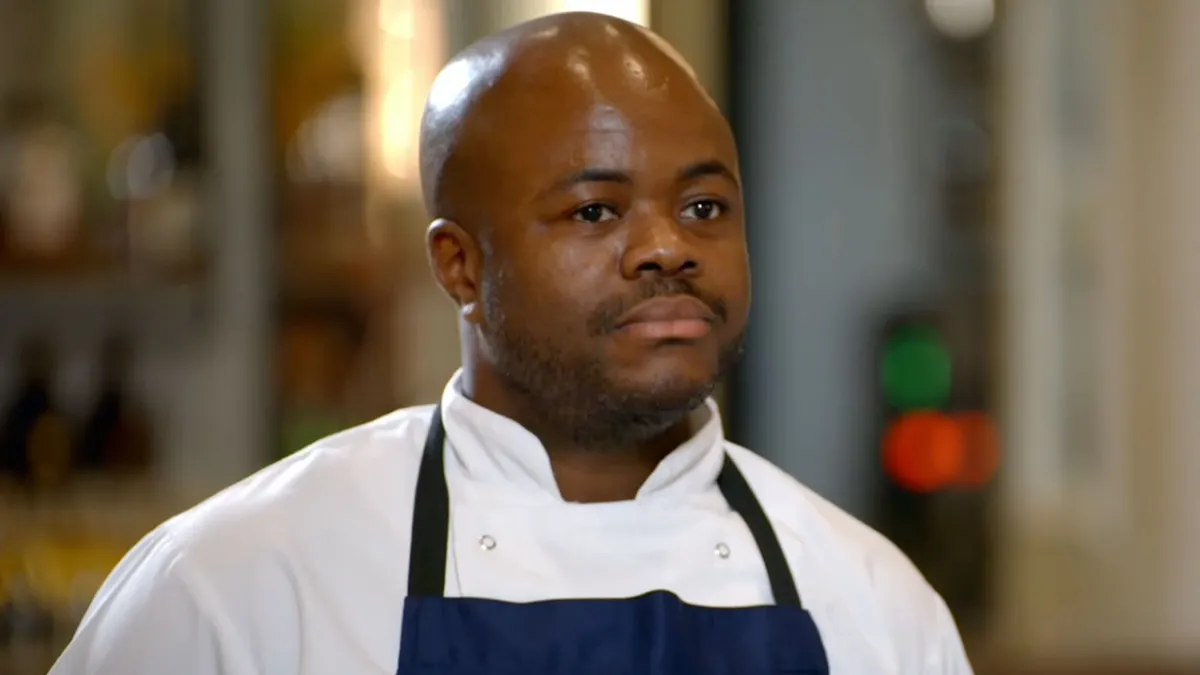 Chef Dom Taylor smiling in a kitchen.