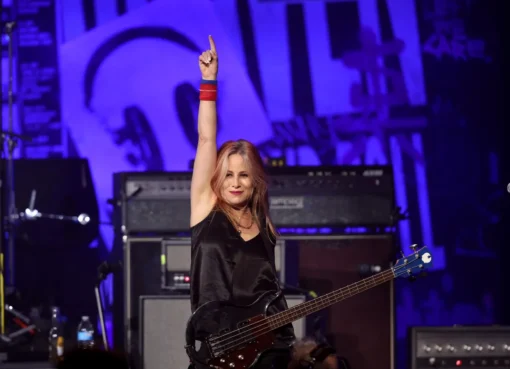 Photo of Jennifer Finch playing bass guitar on stage.