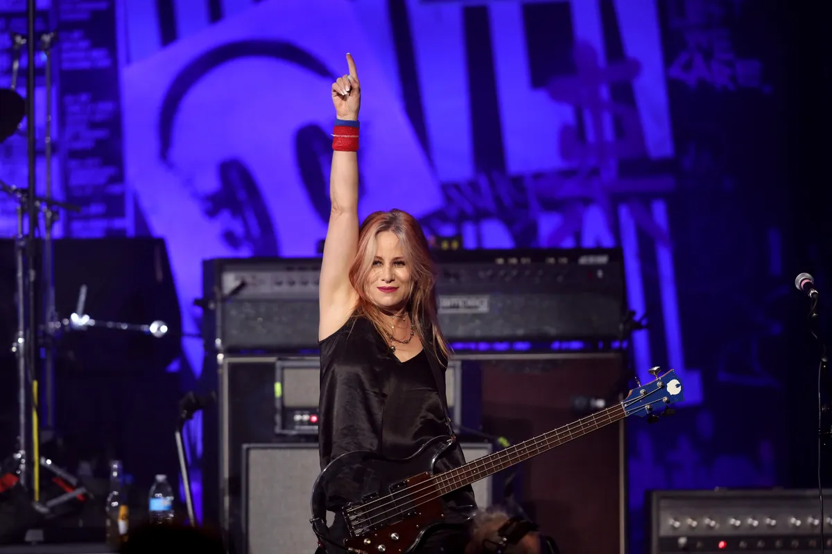 Photo of Jennifer Finch playing bass guitar on stage.