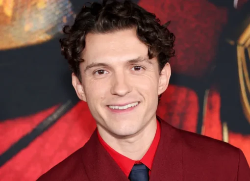 Tom Holland smiling on the red carpet at the Spider-Man premiere