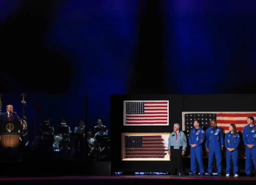 Donald Trump speaking on a stage decorated with historical American flags and veterans.