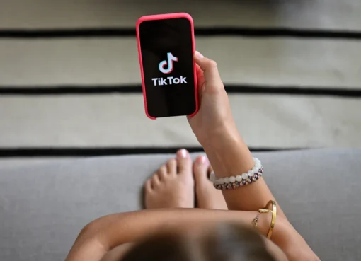 A phone screen displaying the TikTok app logo, against a slightly blurred background, suggesting digital content.