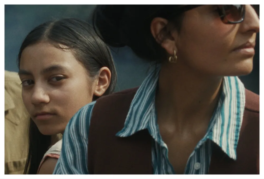 A film poster for 'Our Share of Sand' showing a young girl in a rural Indian setting looking thoughtful.