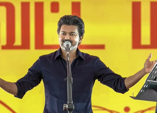 Actor Vijay speaking at a press event.