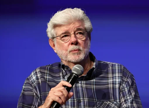 George Lucas smiling thoughtfully, perhaps gesturing during an interview.