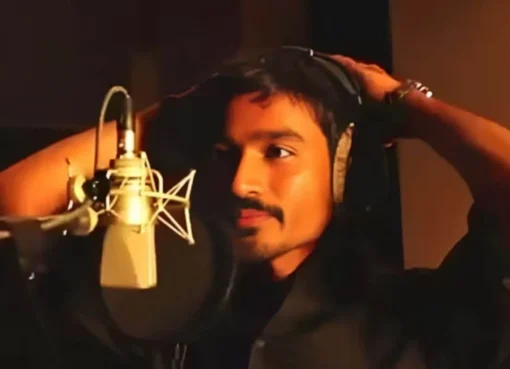 Dhanush looking thoughtful on a film set, showing a reflective moment.