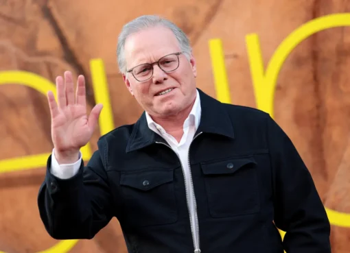 Close-up of David Zaslav smiling, perhaps looking at a stock ticker.