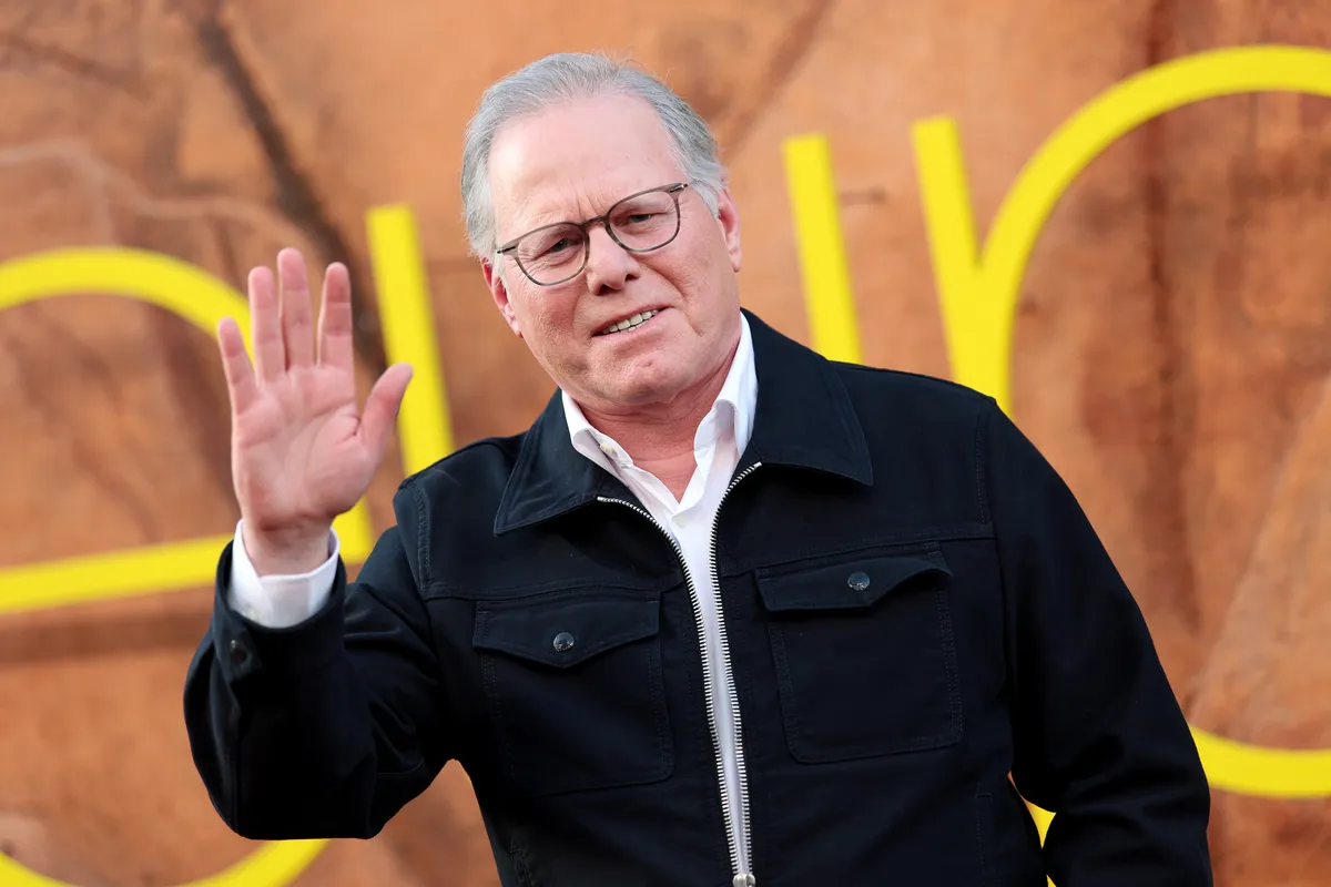 Close-up of David Zaslav smiling, perhaps looking at a stock ticker.