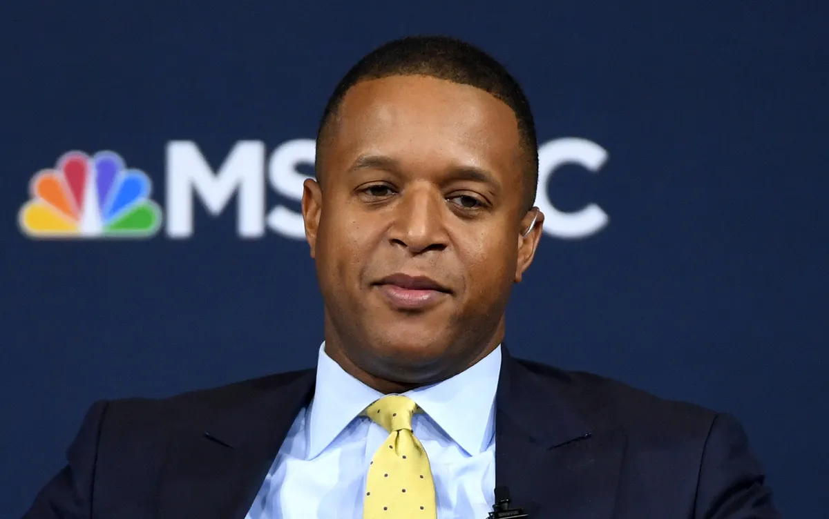 Craig Melvin sits at the Today show desk, looking serious and calm while reporting.