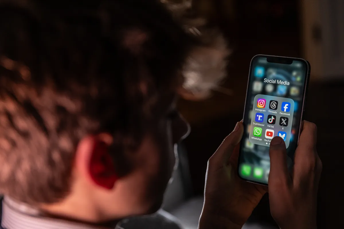 A smartphone screen showing social media apps fading out at midnight, with a digital clock striking 12.