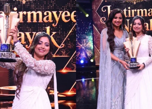 Jyotirmayee Nayak smiling and holding the Indian Idol 16 trophy with confetti falling around her.