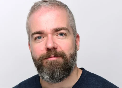 David F. Sandberg smiling on a film set.