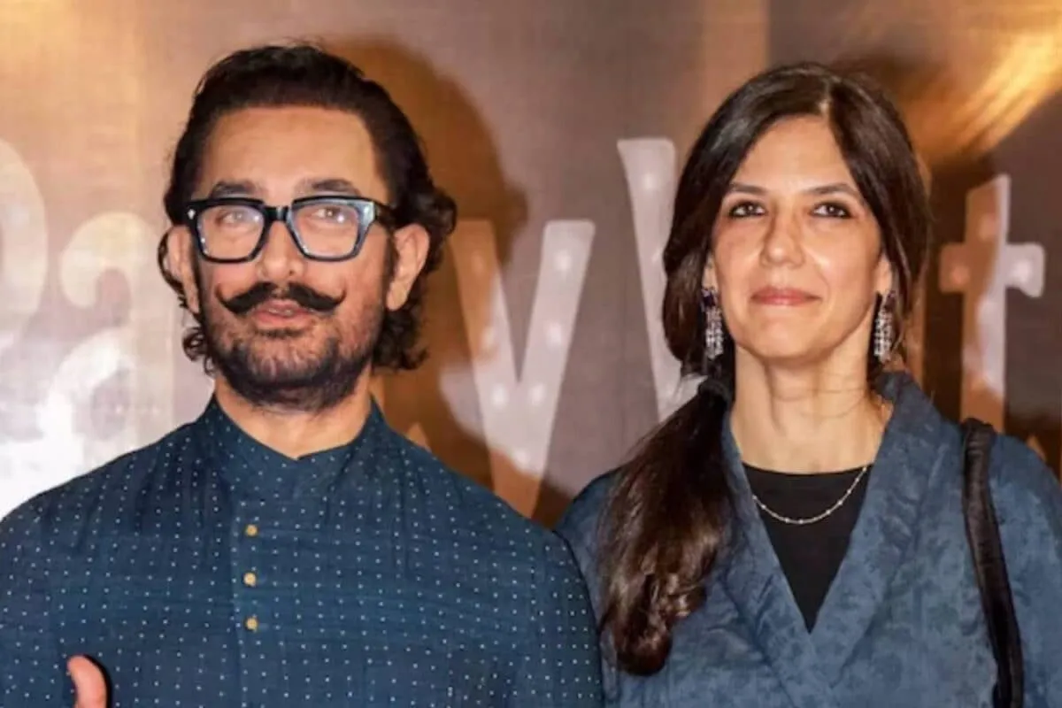 Aamir Khan standing with a serious expression, surrounded by security guards.