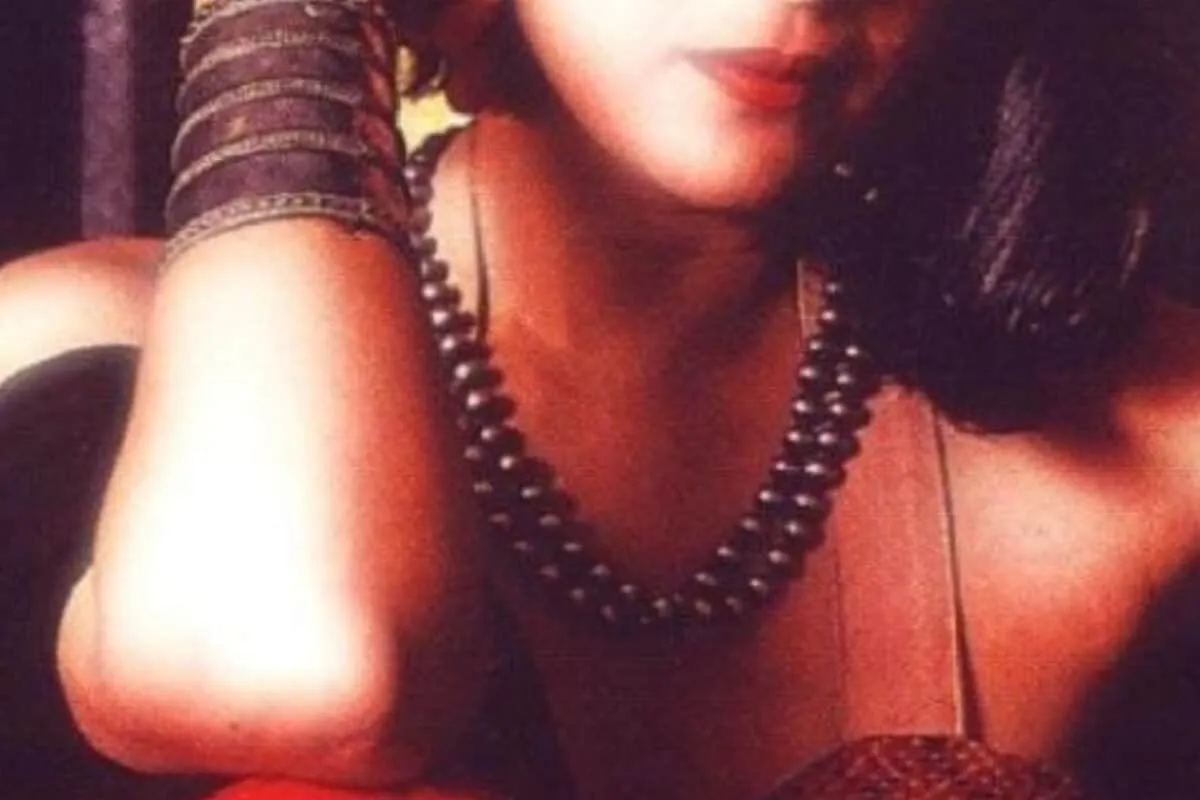 A woman looking determined, holding a child's hand, against a bright background.