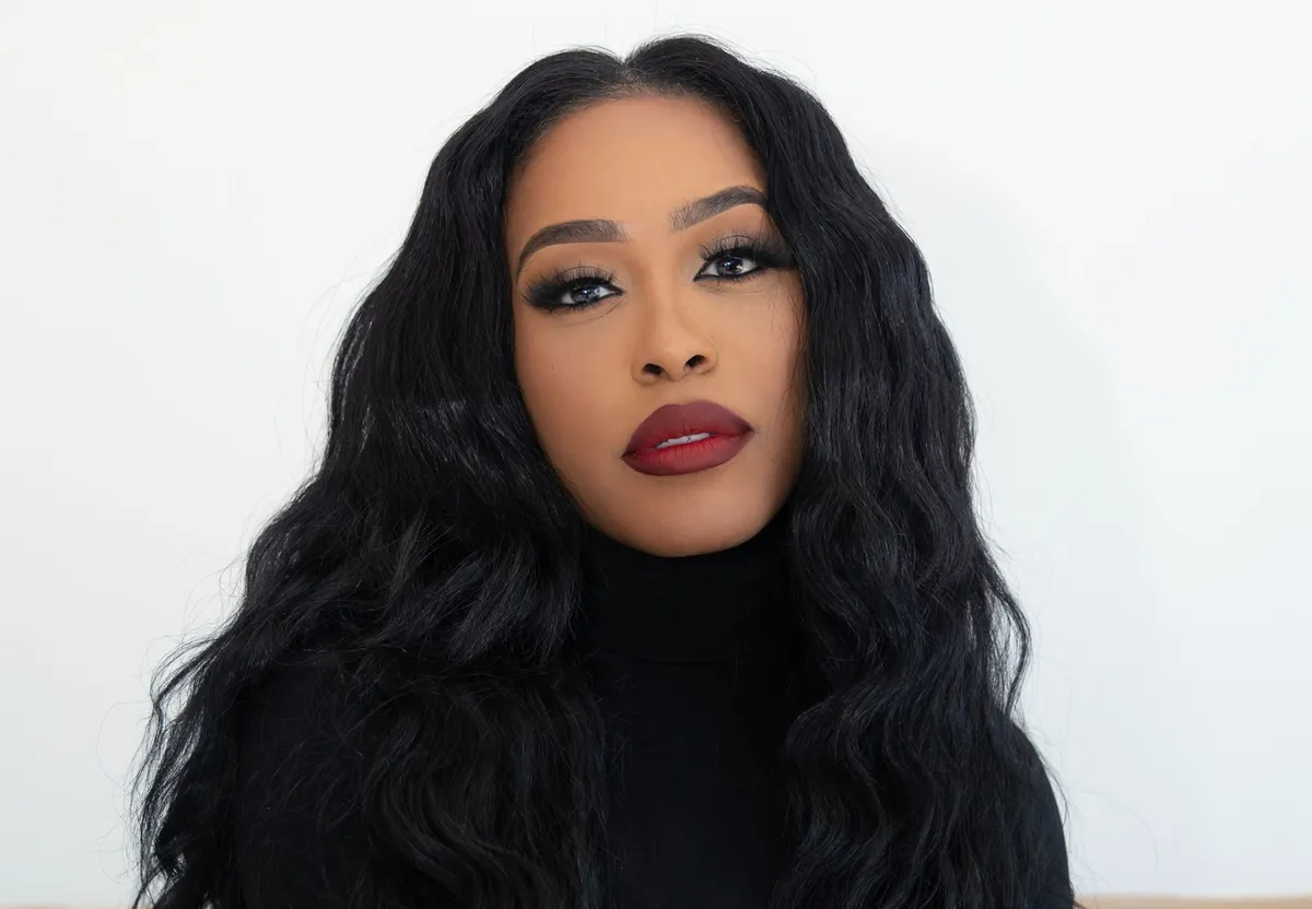 DomiNque Perry smiling brightly, radiating confidence.