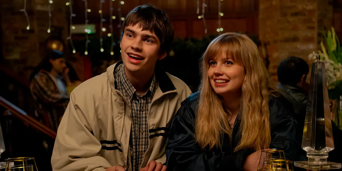 A diverse group of young adults laughing together at a vibrant, modern cafe.