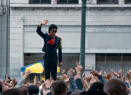 A cinematic shot of a Michael Jackson impersonator on stage, bathed in a spotlight.