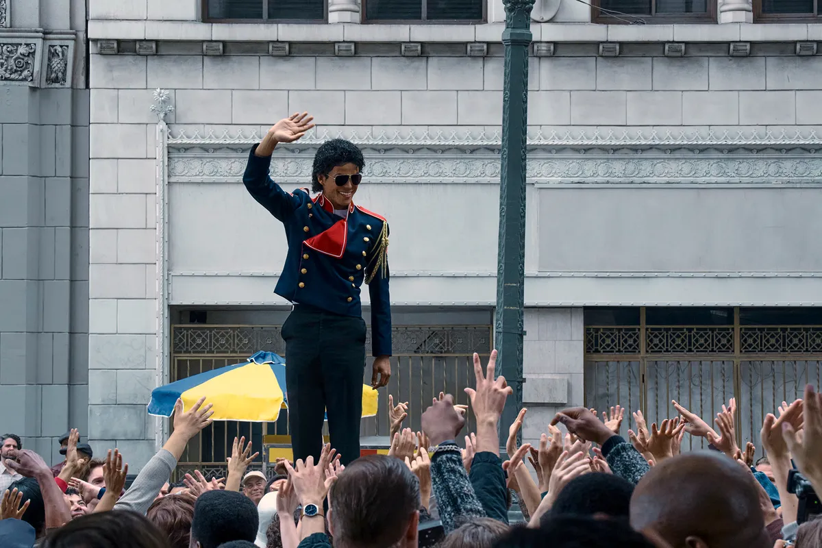 A cinematic shot of a Michael Jackson impersonator on stage, bathed in a spotlight.