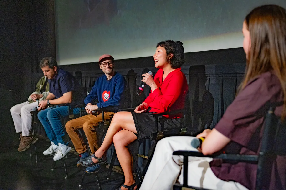 People watching a movie screen showing colorful, AI-generated images.