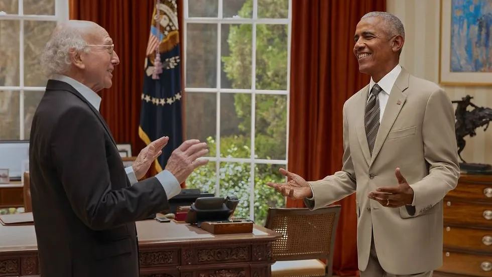 Larry David looking surprised next to a smiling Barack Obama
