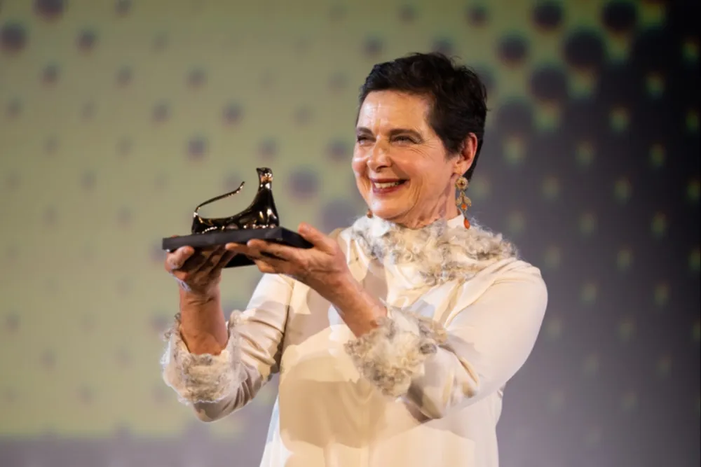 Isabella Rossellini smiling and posing elegantly at an awards ceremony.
