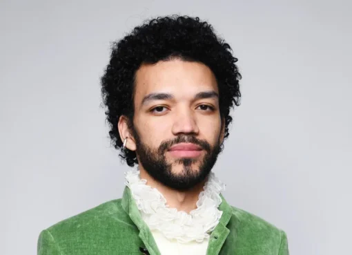 Justice Smith smiles, looking thoughtful.