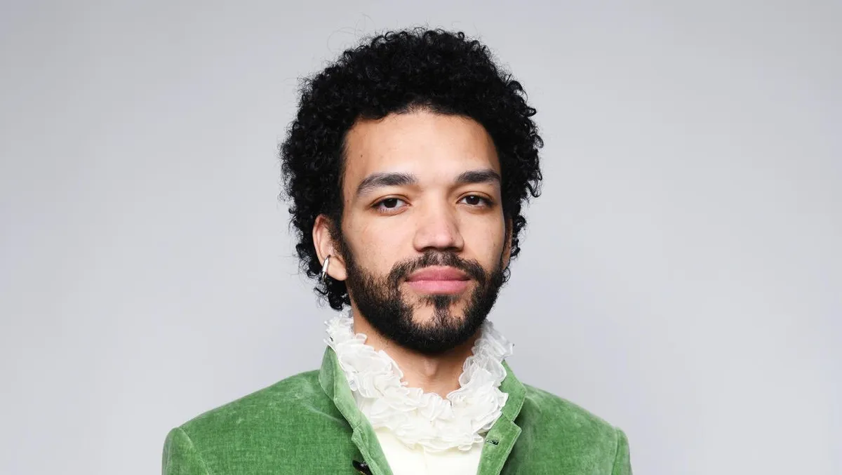 Justice Smith smiles, looking thoughtful.