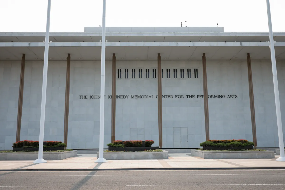 A grand, iconic shot of the Kennedy Center building against a blue sky.