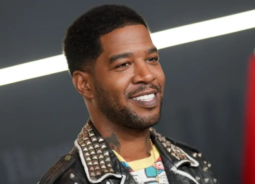 Kid Cudi smiling, perhaps on a film set.
