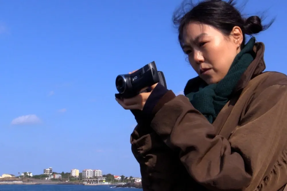 Kim Minhee looking thoughtful in a scene from 'Nowhere to Lay My Eyes'.