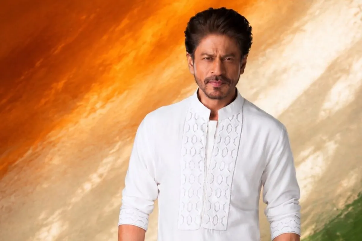 Shah Rukh Khan smiling, with a subtle patriotic background.