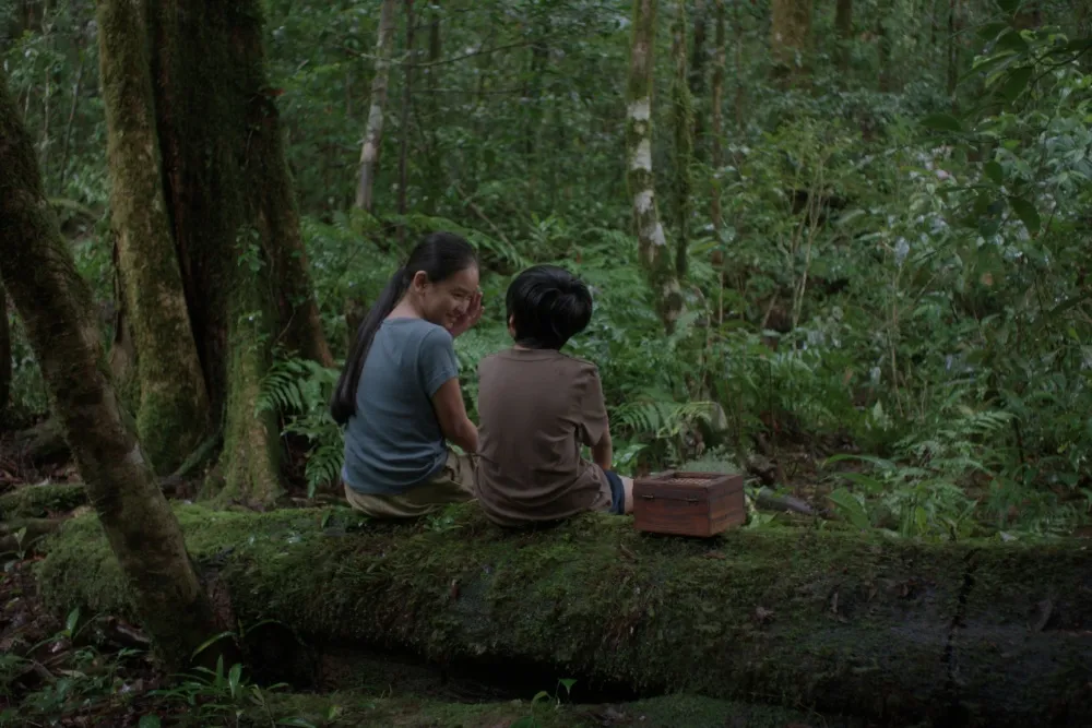 A quiet, reflective scene from Lê Bảo's film 'Hearing' showing an extended family gathered.