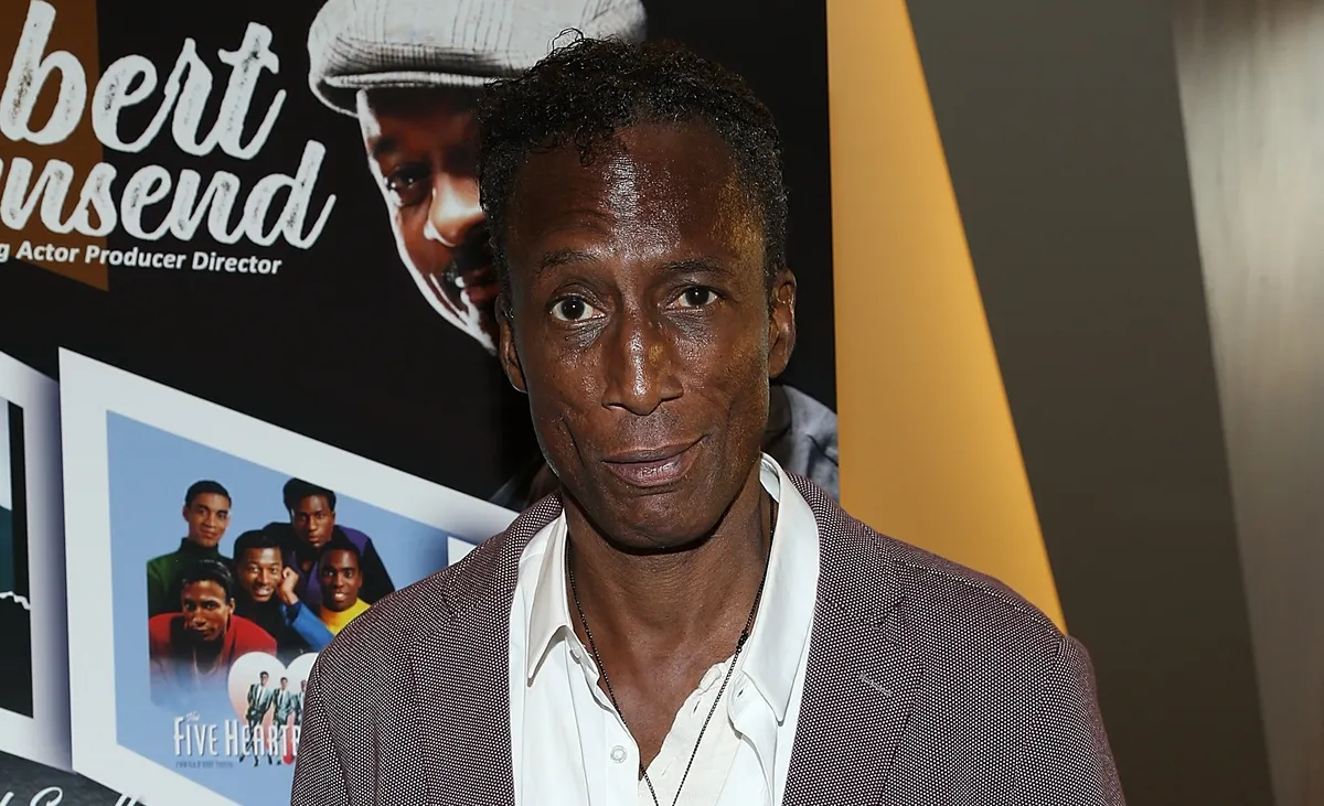Portrait of actor Michael Wright smiling softly.