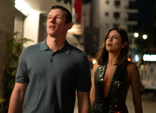 A couple looking lovingly at each other under city lights.